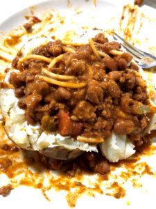 Leftover chili mac topping a baked potato