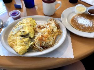 Greek Omelet with hashbrowns, pancake on separate plate, and coffee